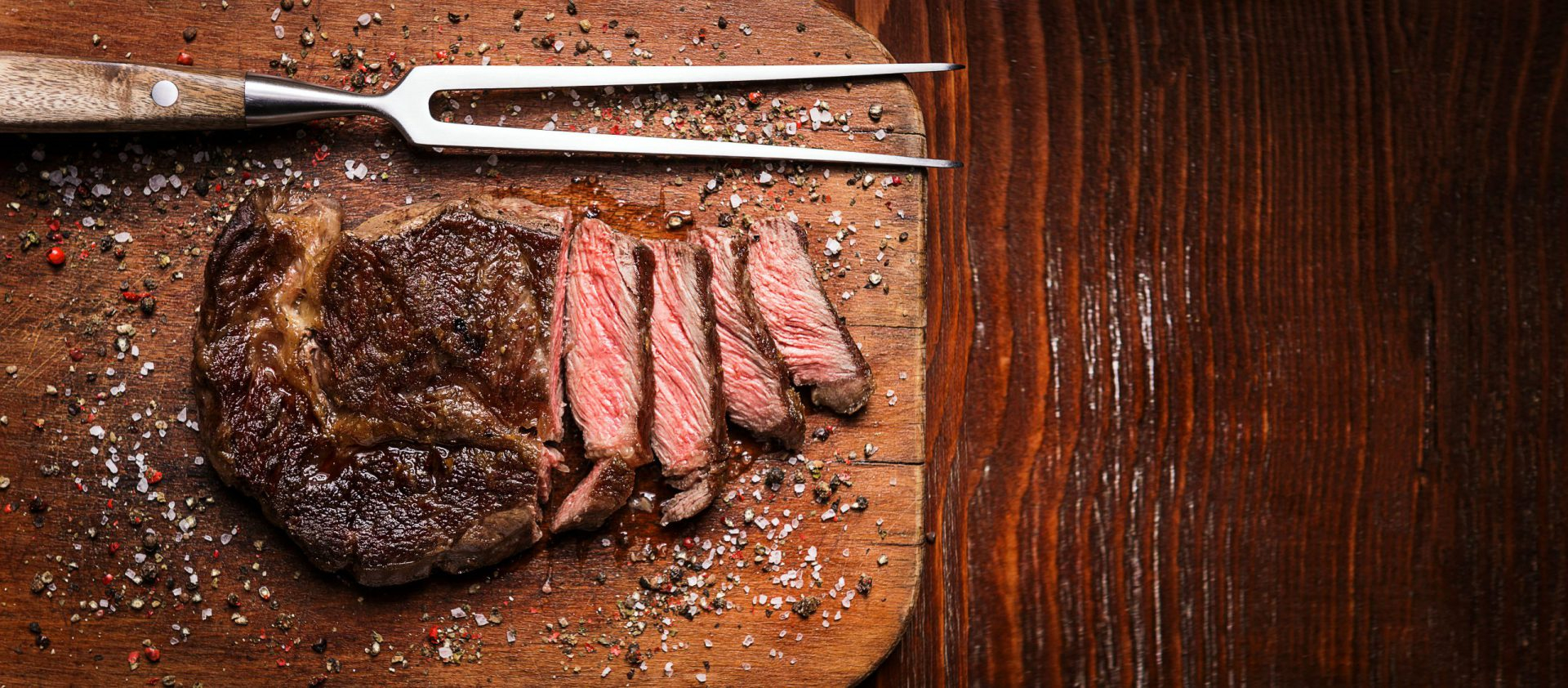 Picanha premium fatiada sobre tábua de madeira rústica escura